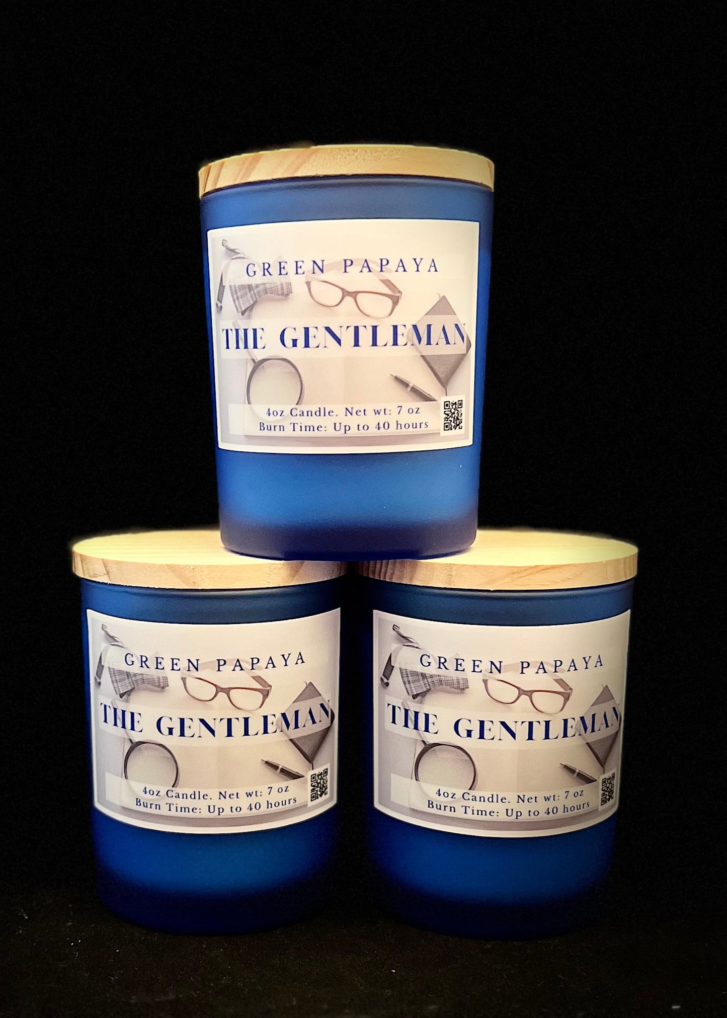 Three candles labeled 'The Gentleman' by Green Papaya on a black background