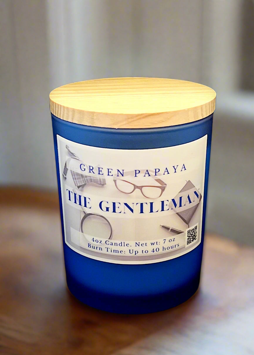 Blue candle with a wooden lid labeled 'Green Papaya The Gentleman' on a black background