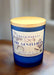 Blue candle with a wooden lid labeled 'Green Papaya The Gentleman' on a black background