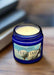 Blue candle jar labeled 'Tee Time' with a white candle inside on a dark background