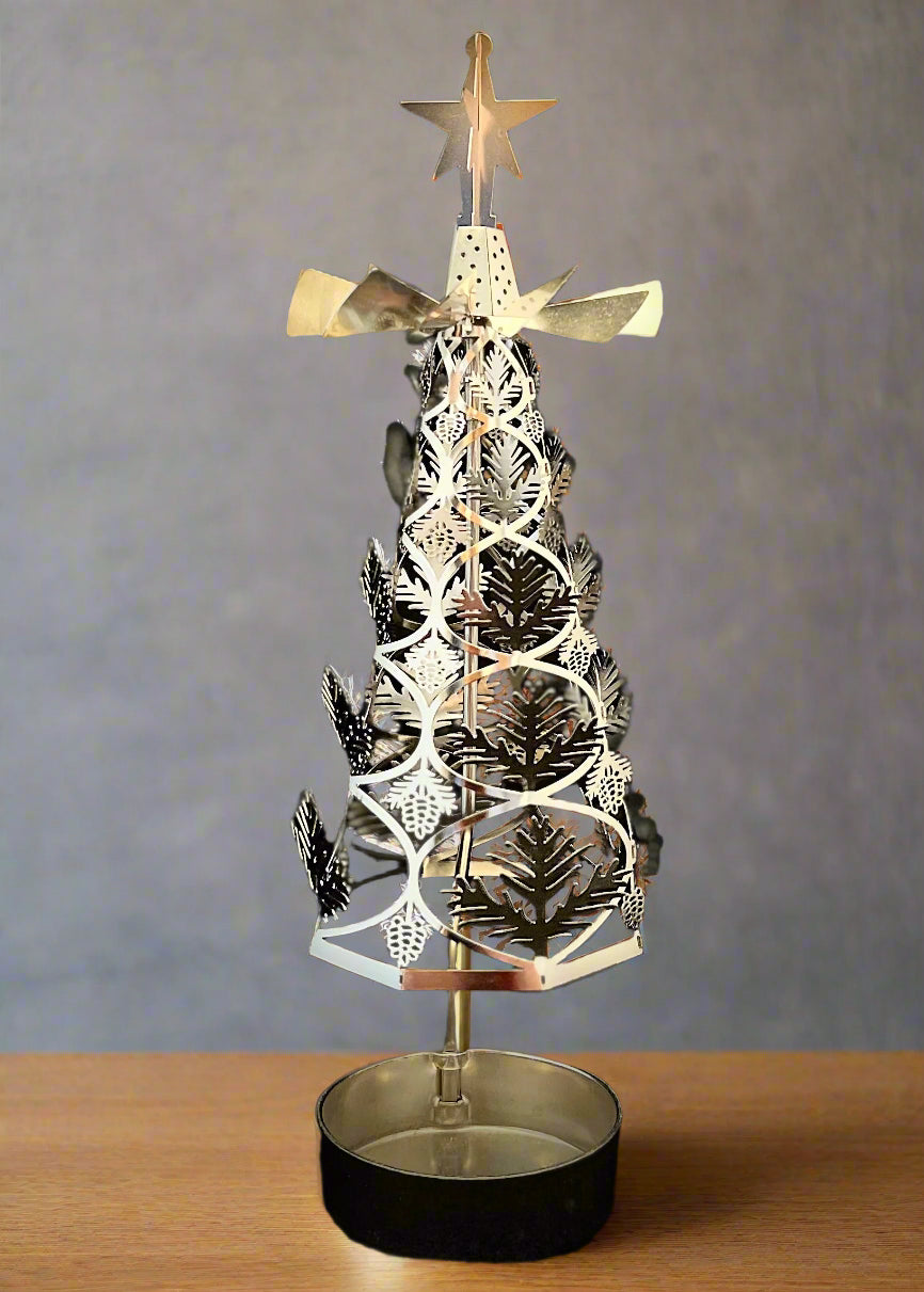 Decorative silver Christmas tree with star on top against a black background