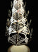 Decorative candle holder with cut-out leaf patterns on a black background