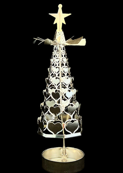 Decorative metal Christmas tree with star on top against a black background