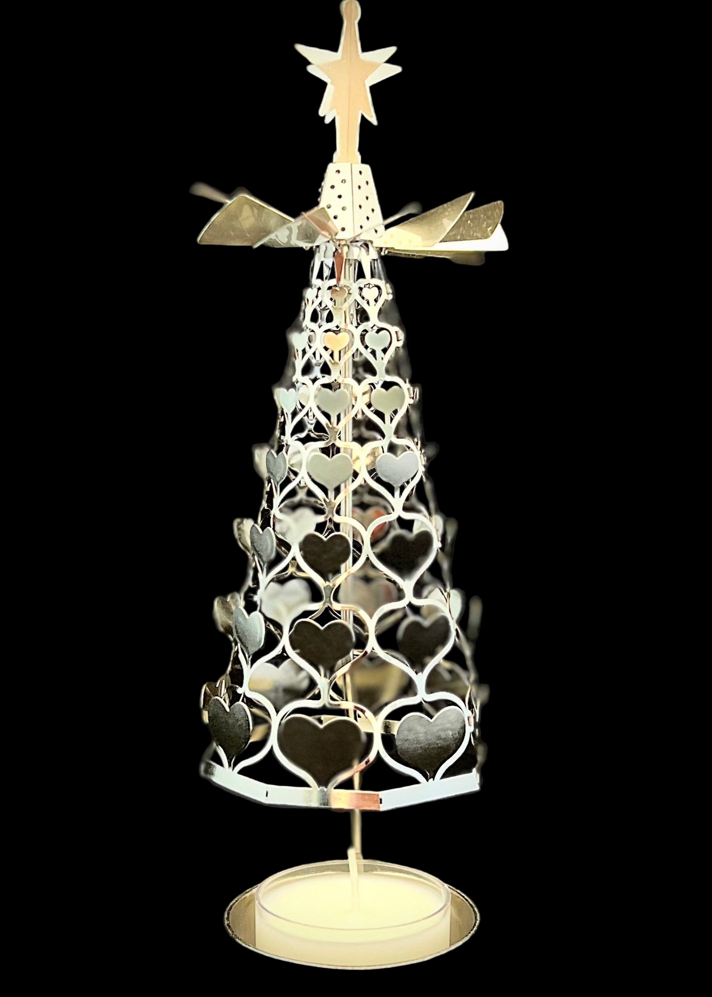 Decorative Christmas tree with heart patterns and a star on top against a black background