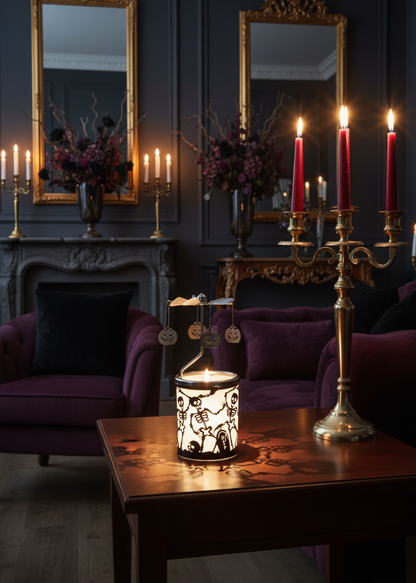 A gothic-style interior scene with purple velvet chairs, ornate gold-framed mirrors, a dark fireplace mantel, and a glowing lantern on a wooden table. A brass candelabra with red taper candles stands prominently on the right.